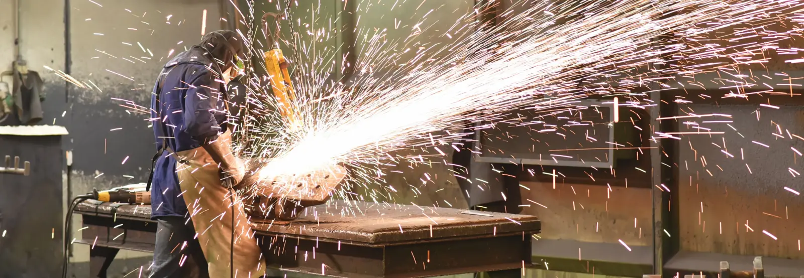 Industrieller Bearbeitungsprozess mit starkem Funkenflug in einer Produktionsumgebung. Die Aufnahme zeigt einen praxisnahen Arbeitsschritt in der Metallbearbeitung und veranschaulicht technische Prozesse in der industriellen Fertigung.